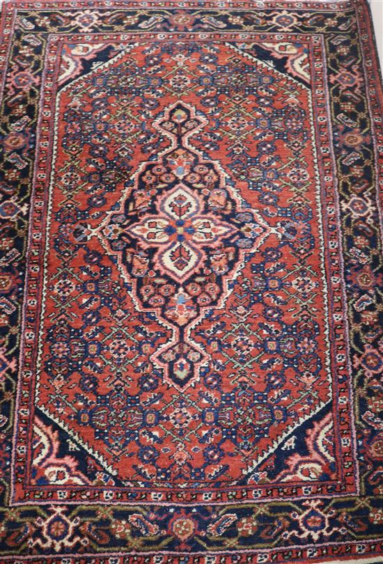 A Persian red ground rug, 5ft 1in by 3ft 9in.